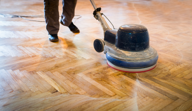 Einscheibenmaschine reinigt Holzboden